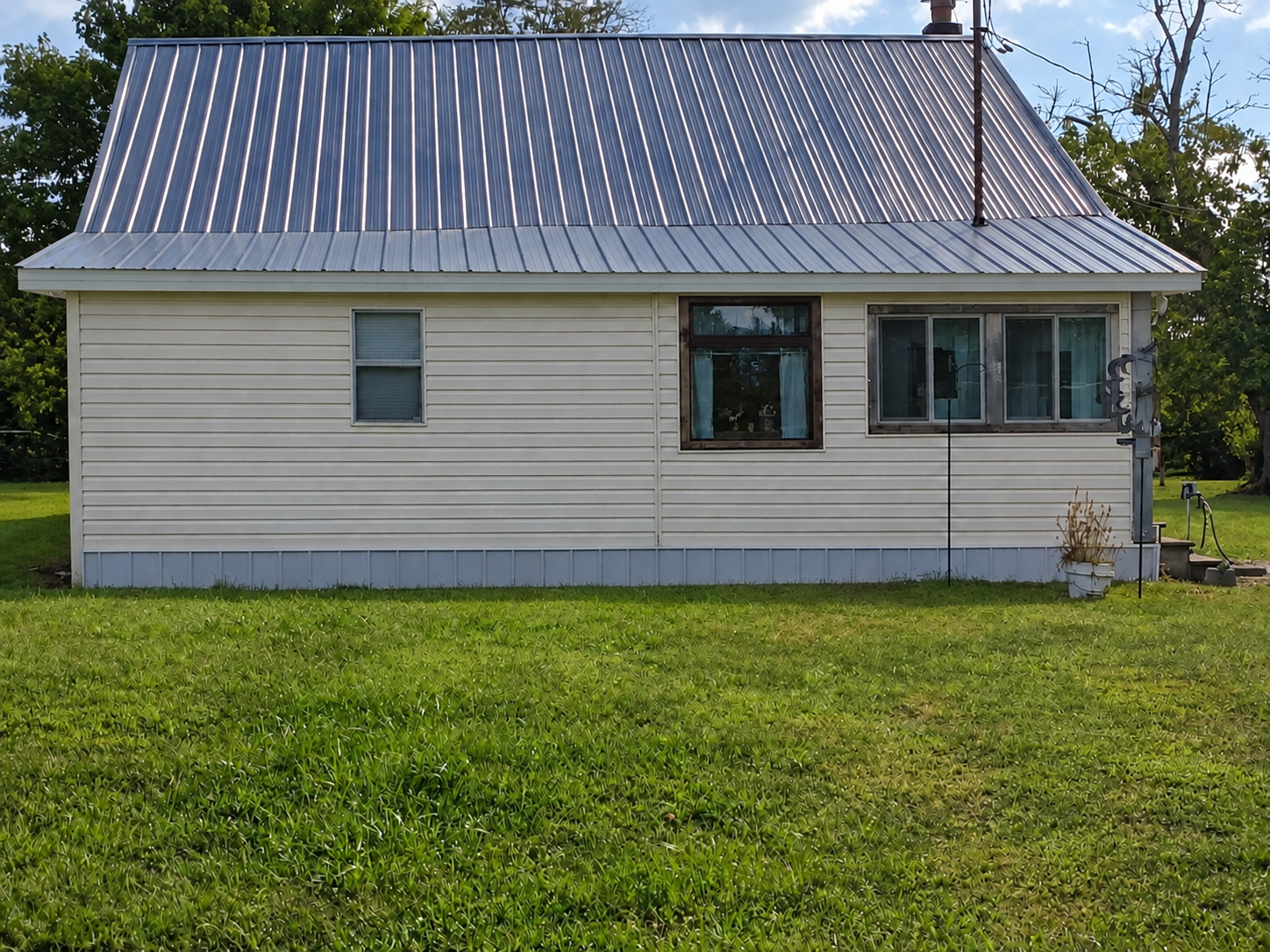 Side view showing the newly installed cameo-colored vinyl siding